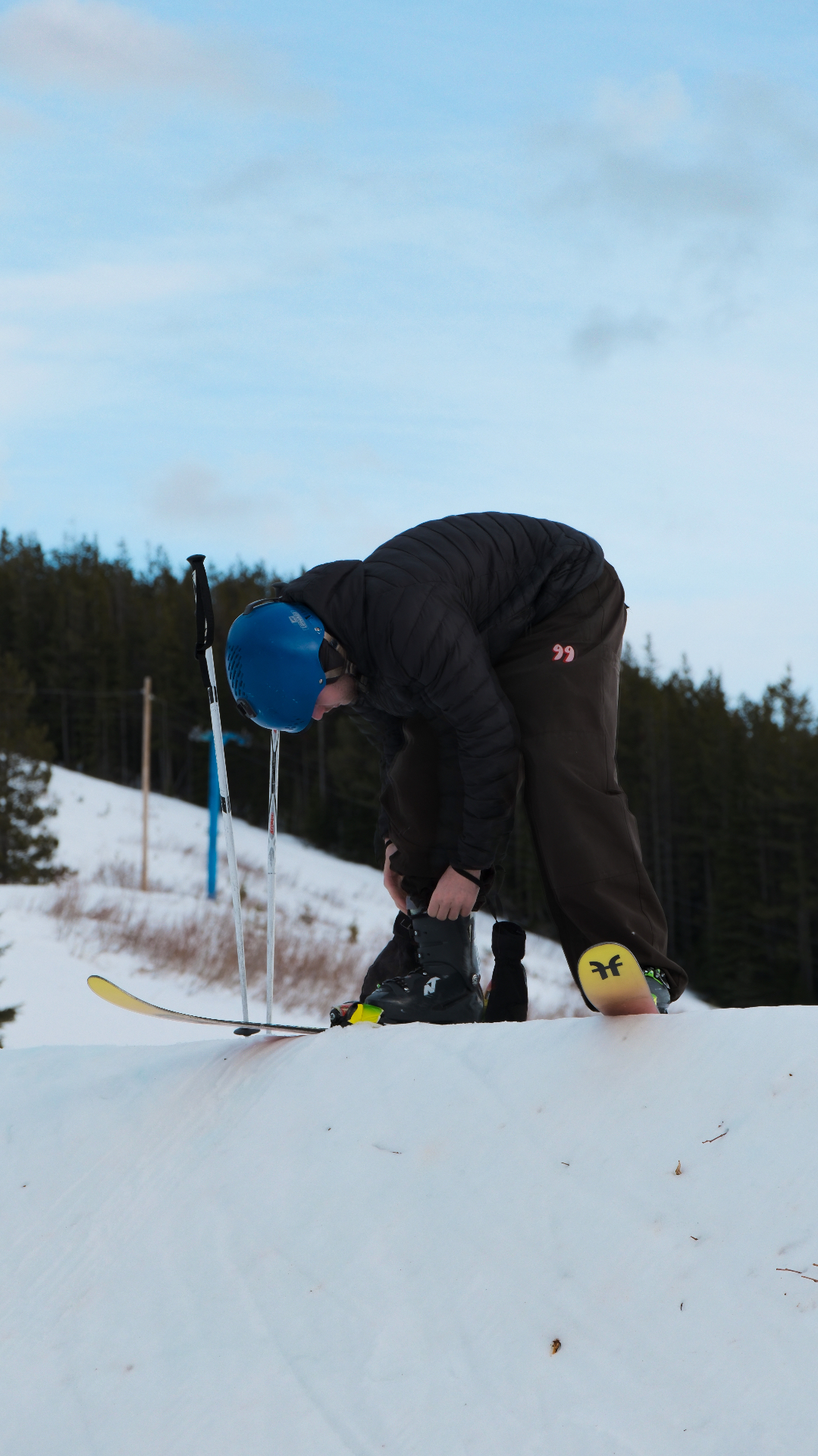 Skieur ajustant sa botte avant une descente